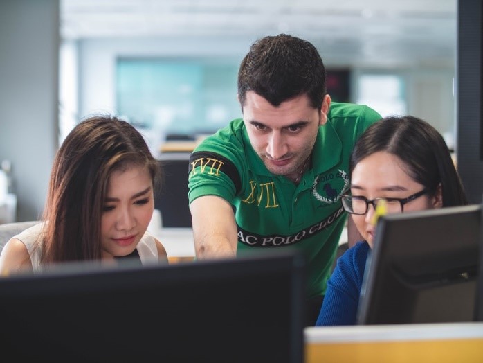 Three people looking onto computer screen
